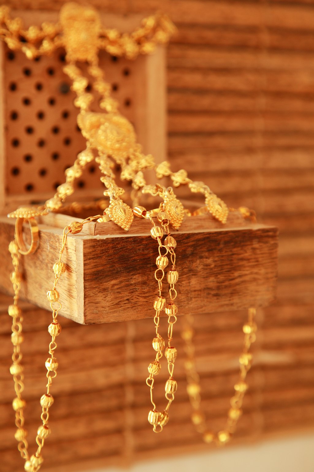 Colar de ouro apoiado em caixa de madeira